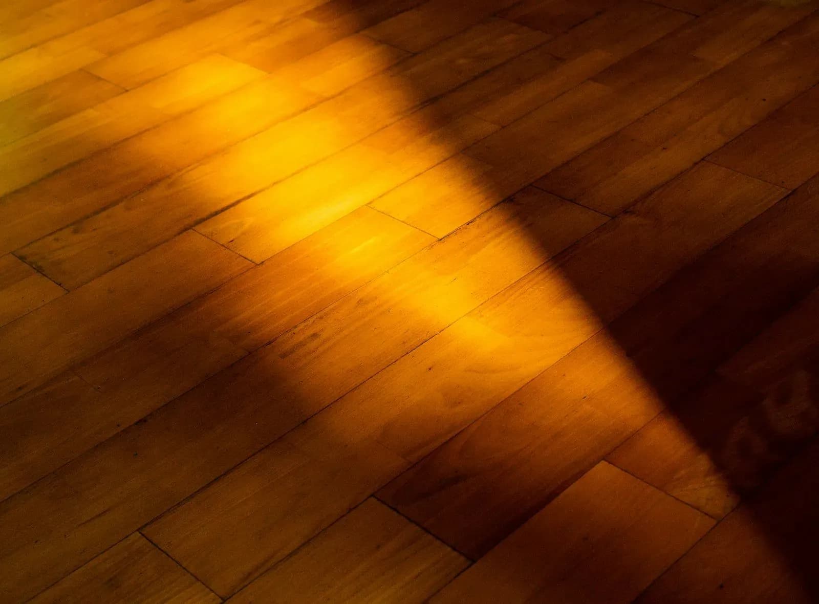 Close-up of warm-toned hardwood flooring with light and shadow