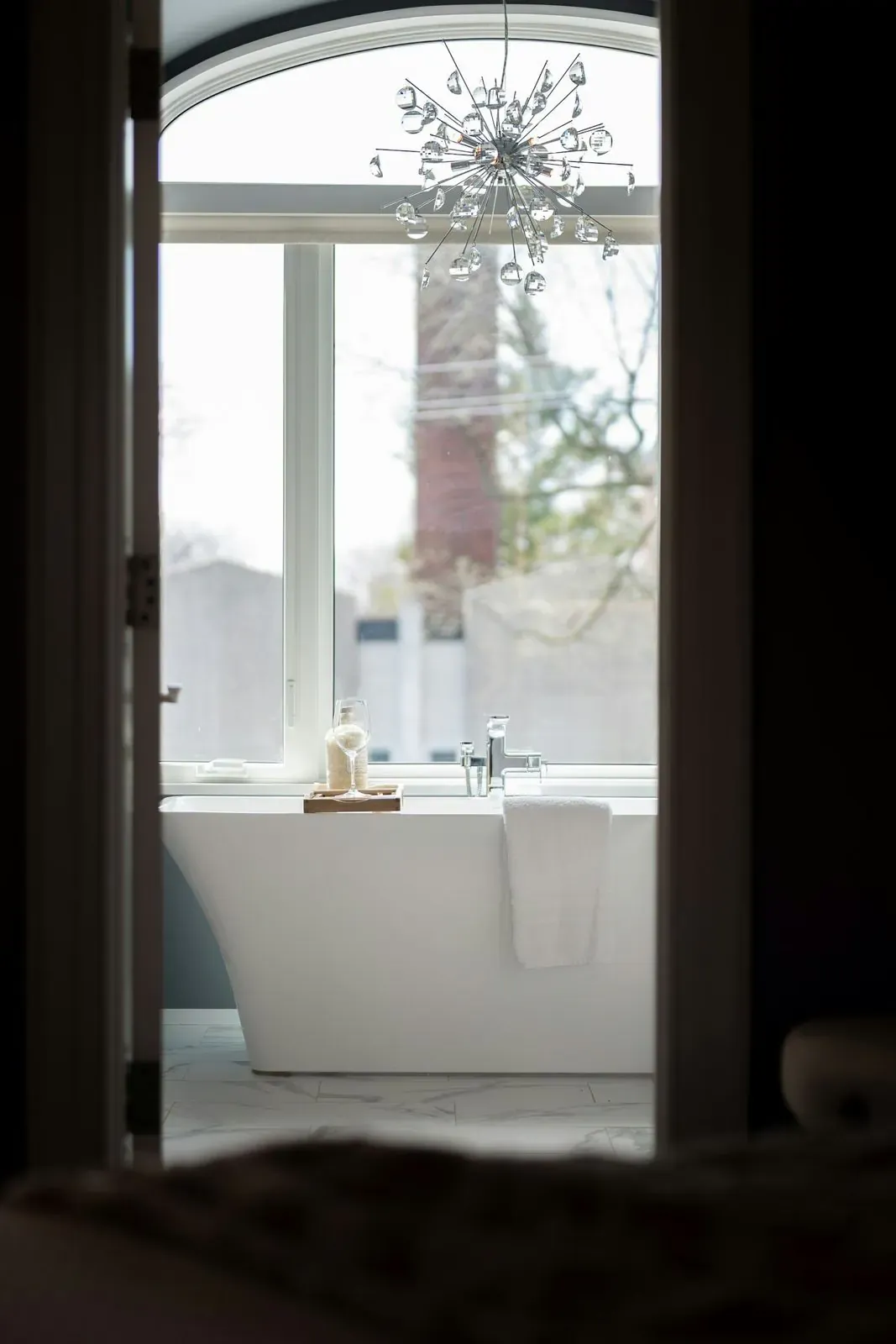 Modern freestanding bathtub beside a large window