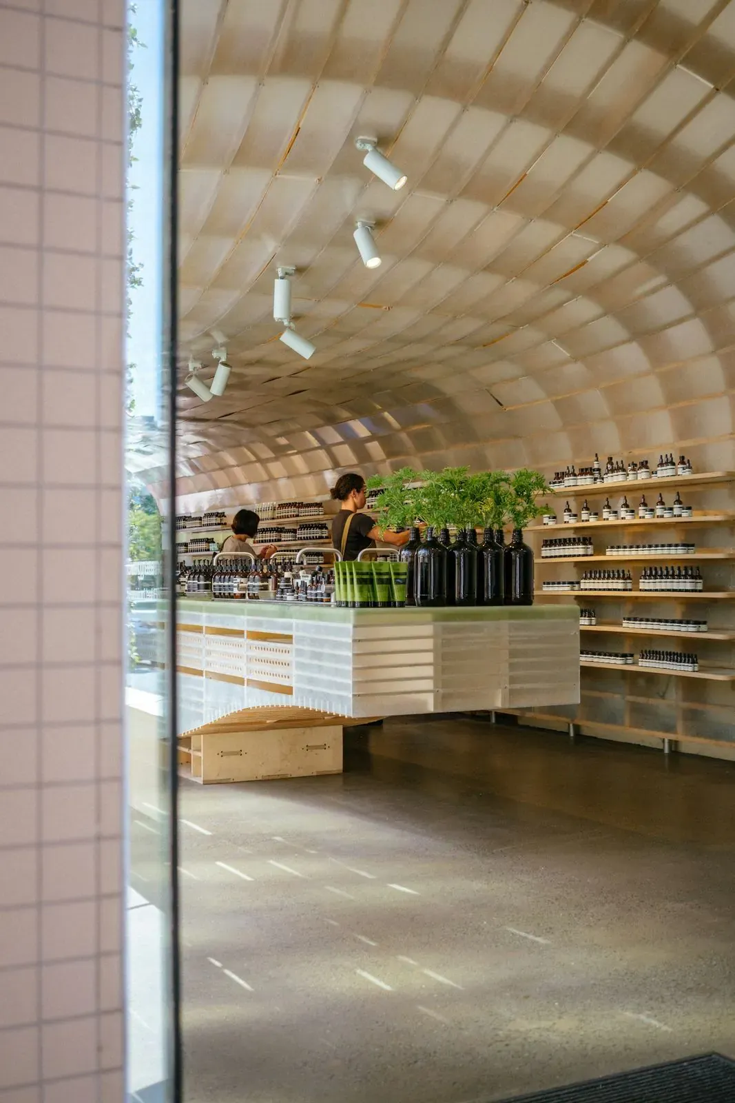 Curved wooden retail store interior with well-lit product shelves